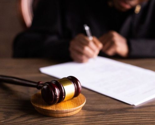 Judge writing with gavel present during Tax Court of Canada - procedure and process guide, explained by KR Law Firm - Tax Law Firm in Toronto