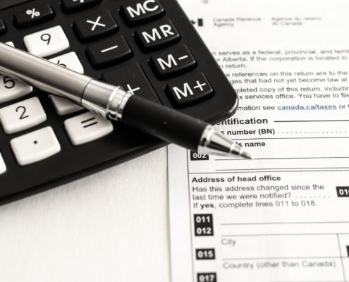 Pen, calculator, and CRA form for understanding tax litigation in Toronto explained by KR Law Firm - A Canadian Tax Law Firm in Toronto